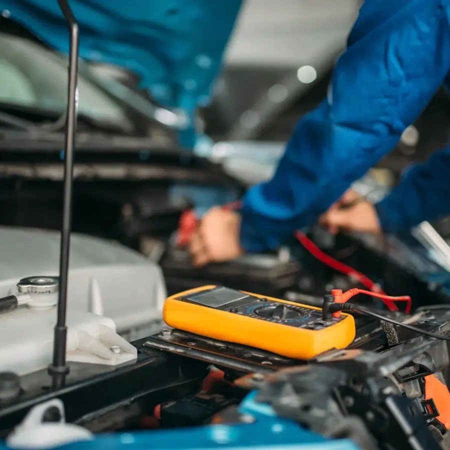 Mécanicien utilisant un multimètre sur une voiture